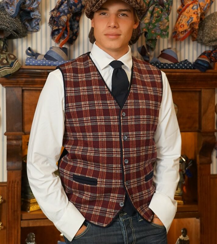 Merino wool gilet patterned plaid-like patterned gilet in red amaranth and white, with navy blue border and blue solid color back. With 5 buttons and two pockets, patterned like the classic vest. 100% pure merino wool made in Italy.